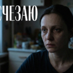 Молодая мама в тени детской кроватки иллюстрирует симптомы депрессии после родов и чувство внутреннего одиночества.