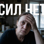Уставшая женщина сидит за столом, обхватив голову руками, что символизирует хроническую усталость и упадок сил.